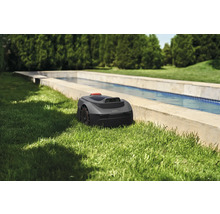 Robotmaaier in de tuin naast een waterbassin