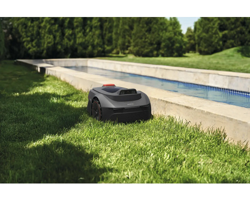 Robotmaaier in de tuin naast een waterbassin