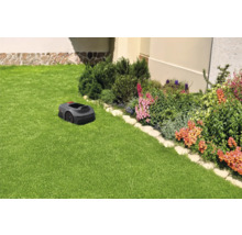 Robotmaaier op een gazon naast een bloembed