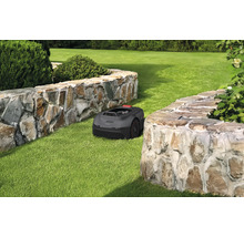 Robotmaaier op gazon tussen twee stenen muren