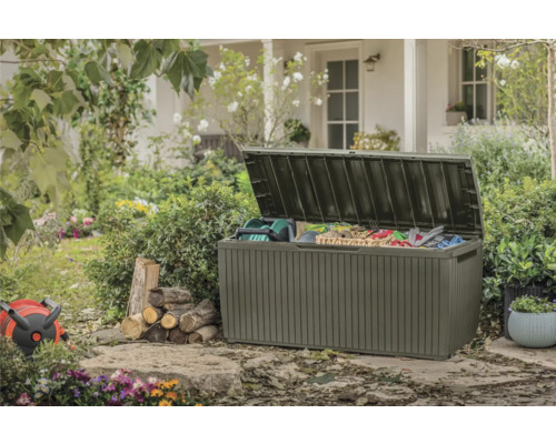 Open tuinkist met tuingereedschap en accessoires in groene tuin