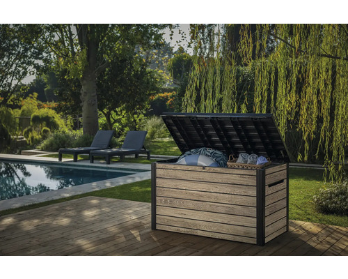Tuinscene met een open kunststof opbergbox op een terras met zwembad en ligstoelen
