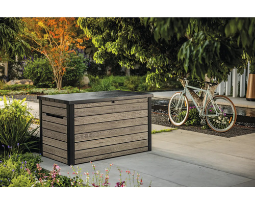 Foto van een kunststof opbergbox in de tuin met een fietsdecoratie