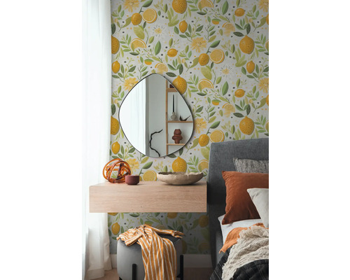 Slaapkamer met muurbehang versierd met citroenen en bloemmotieven, aangevuld door een spiegel, een zwevende plank en een bed.