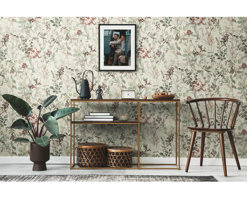 Woonkamer met bloemenbehang, console en decoraties zoals planten en manden