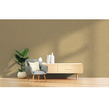 Woonkamer met fauteuil, plant en dressoir tegen een gestructureerde muur