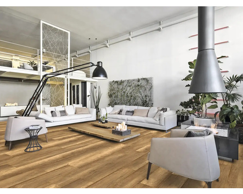 Lichte woonkamer met houten vloer, witte banken, fauteuils en open haard