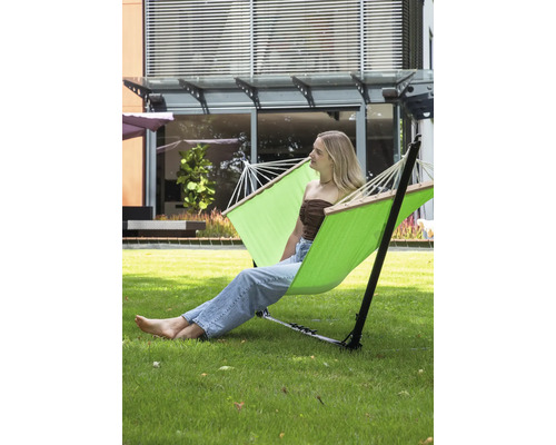 Vrijstaande hangmat met een vrouw die ontspant in de tuin.