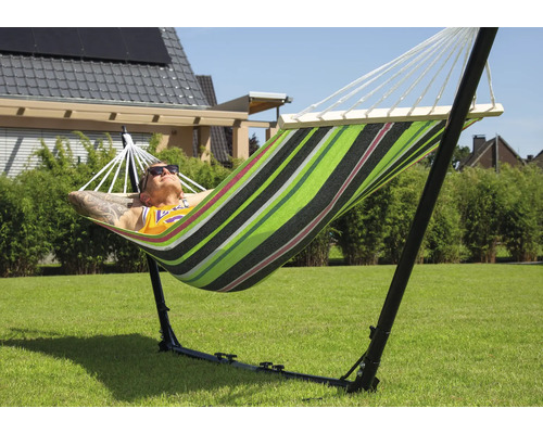 Man ontspant in een gestreepte hangmat met frame in de tuin.