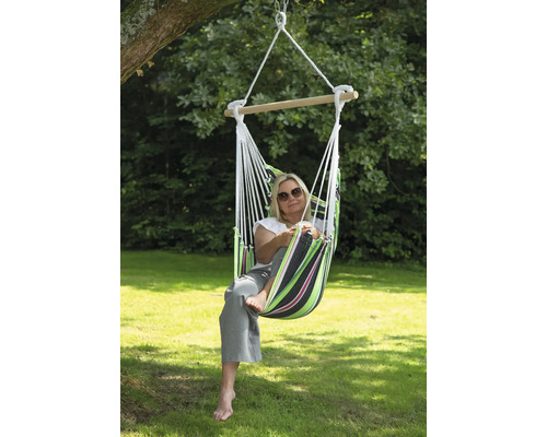 Vrouw ontspant in een hangmatstoel in de tuin