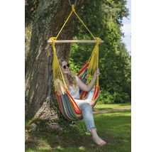 Vrouw ontspant in een kleurrijke hangstoel die aan een boom is bevestigd.