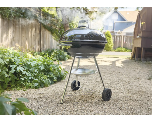 Bolvormige barbecue in de tuin met rookontwikkeling.