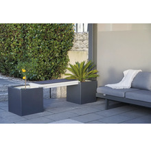 Tuinmeubelopstelling met plantenbakken die dienst doen als bank en een bank op een terras.