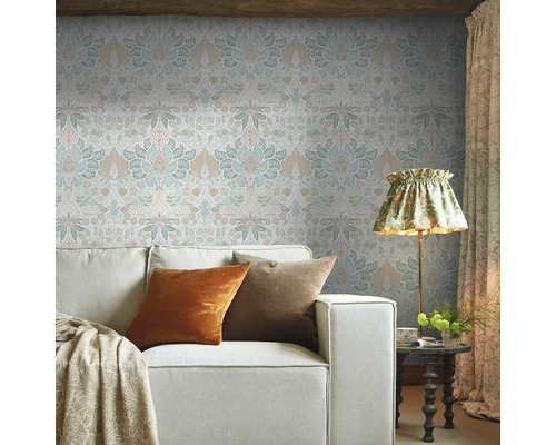 Woonkamer met patroonbehang, bank en staande lamp