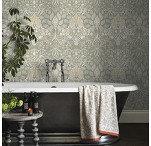 Badkamer met bloemenbehang, bad en bijzettafel.