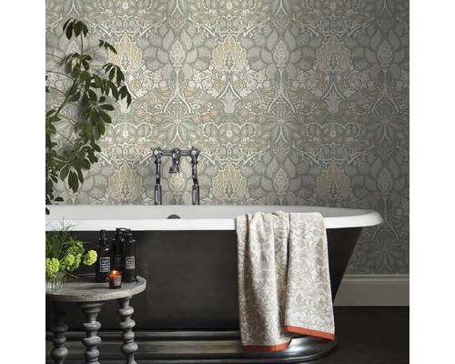 Badkamer met bloemenbehang, bad en bijzettafel.