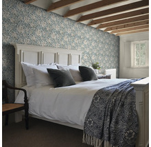 Slaapkamer met bed en bloemenbehang