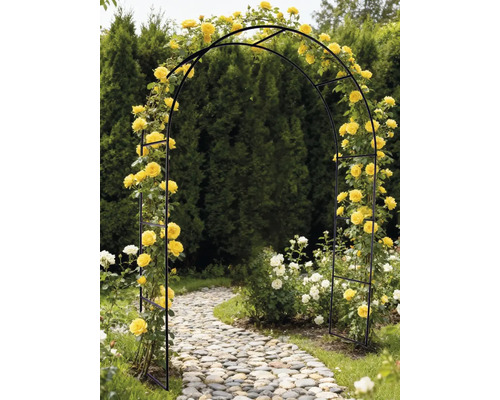Zwarte rozenboog met gele rozen in een tuin boven een stenen pad