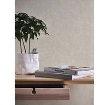 Close-up van een tafel met een plant in een papieren bak en twee boeken