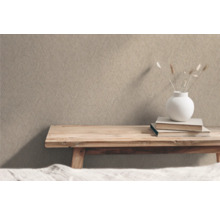 Beige structuurbehang in interieur met houten tafel, boeken en decoratie