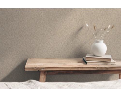 Beige structuurbehang in interieur met houten tafel, boeken en decoratie