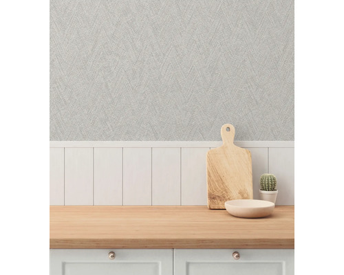 Decoratieve scène met een werkblad, een houten snijplank, een kom, een cactus en een gestructureerd behang.