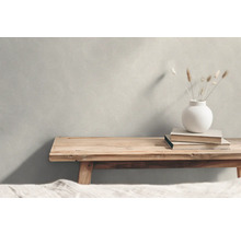 Scene met een gestructureerd behang, een houten bank, boeken en een vaas met planten