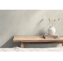 Decoratieve scène met houten bank, boeken en een vaas met droogbloemen.