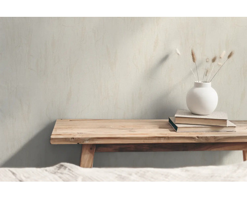 Decoratieve scène met houten bank, boeken en een vaas met droogbloemen.