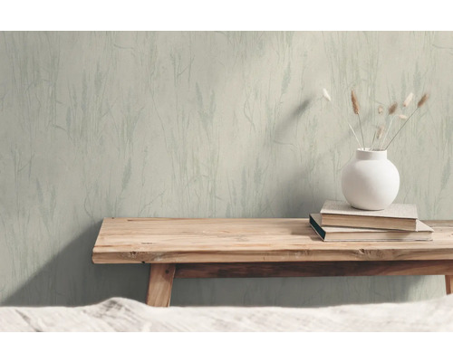 Woonkamer met patroonbehang, houten bedbank, boek en vaas