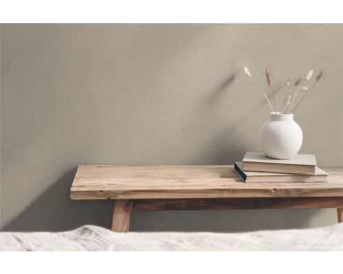 Houten bank met vaas en boeken voor een muur