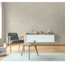 Woonkamer met patroonbehang, fauteuil, salontafel en dressoir