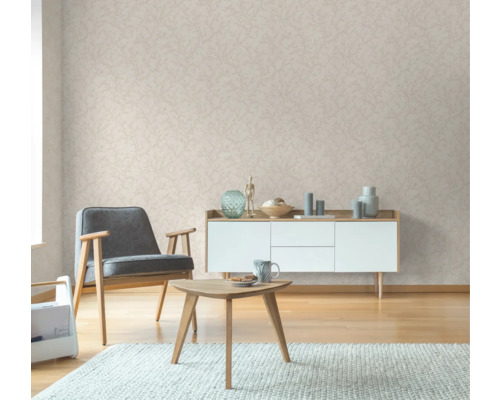 Woonkamer met fauteuil, tafel, dressoir en behang met print