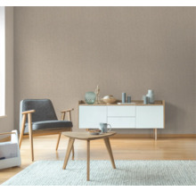 Woonkamer met beige structuurbehang, fauteuil en dressoir