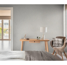 Slaapkamer met patroonbehang, bureau, stoel en bed