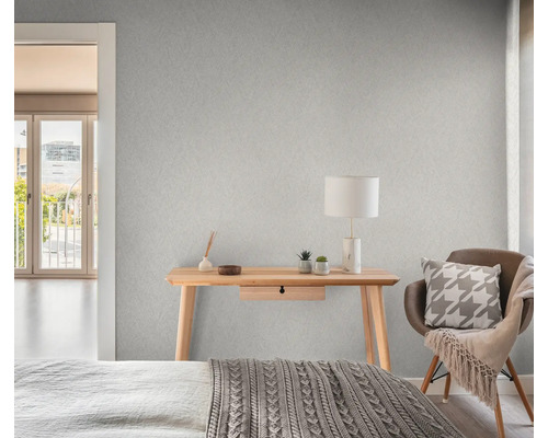 Slaapkamer met patroonbehang, bureau, stoel en bed