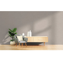 Woonkamer met fauteuil, kamerplant en dressoir