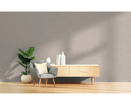 Woonkamer met fauteuil, kamerplant en dressoir