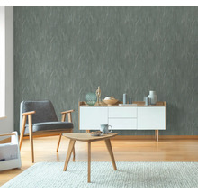 Woonkamer met grijs behang, fauteuil en houten meubels