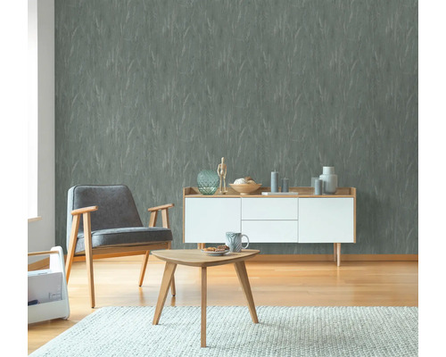 Woonkamer met grijs behang, fauteuil en houten meubels