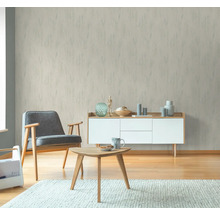 Woonkamer met fauteuil, salontafel en behang met patroon