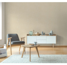 Woonkamer met fauteuil, salontafel en dressoir voor een patroonbehang