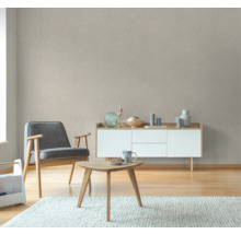 Woonkamer met fauteuil, salontafel, dressoir en patroonbehang