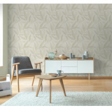 Woonkamer met bladerbehang, fauteuil, tafel en dressoir