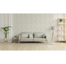 Woonkamer met bank, vloerlamp, plank en behang met bladmotief.