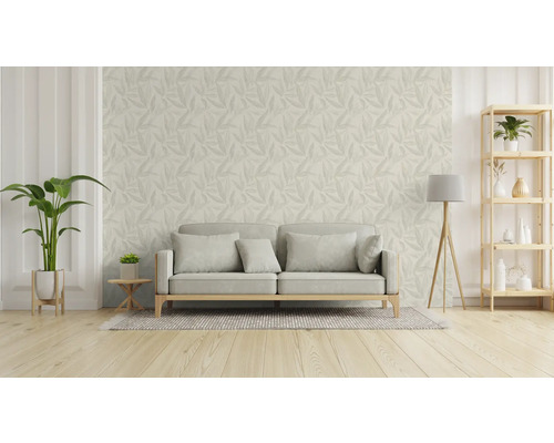 Woonkamer met bank, vloerlamp, plank en behang met bladmotief.