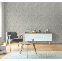 Woonkamer met behang met bladmotief, fauteuil, tafel en dressoir