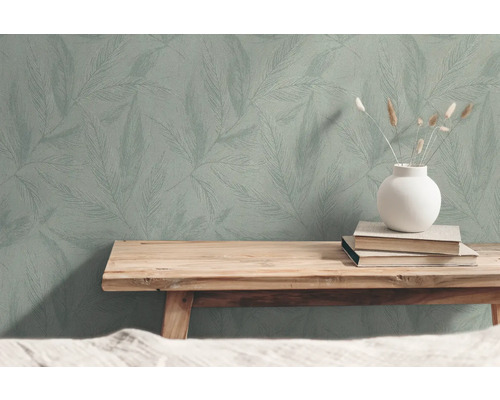 Behang met bladerpatroon, boeken en vaas op houten bank