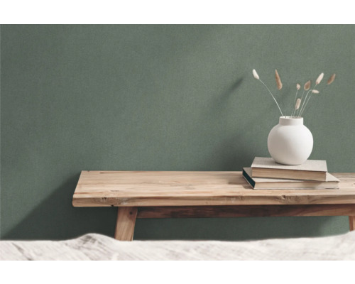 Decoratieve scène met houten tafel, boeken en vaas voor een groene wand