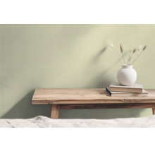 Woonkamer met houten kruk, stapel boeken en bloemenvaas